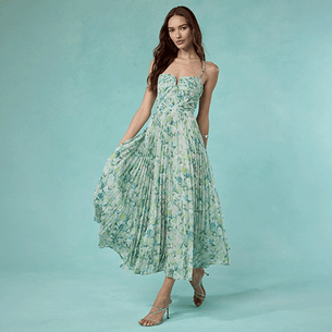 Woman wearing a strapless, flowing green and blue patterned maxi dress with spaghetti straps.