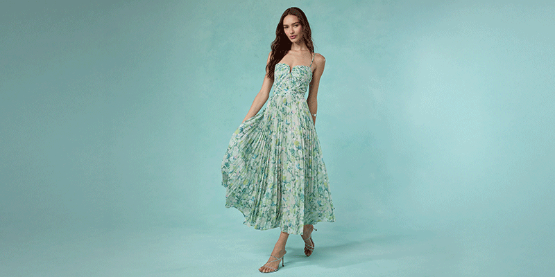 Woman in a strapless, floral print maxi dress with a fitted bodice and flowing skirt.