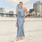 Woman in a light blue halter neck, sleeveless satin gown with a high neckline and side slit.