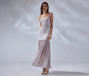 Woman in a white sleeveless fitted dress with a sheer, pleated skirt