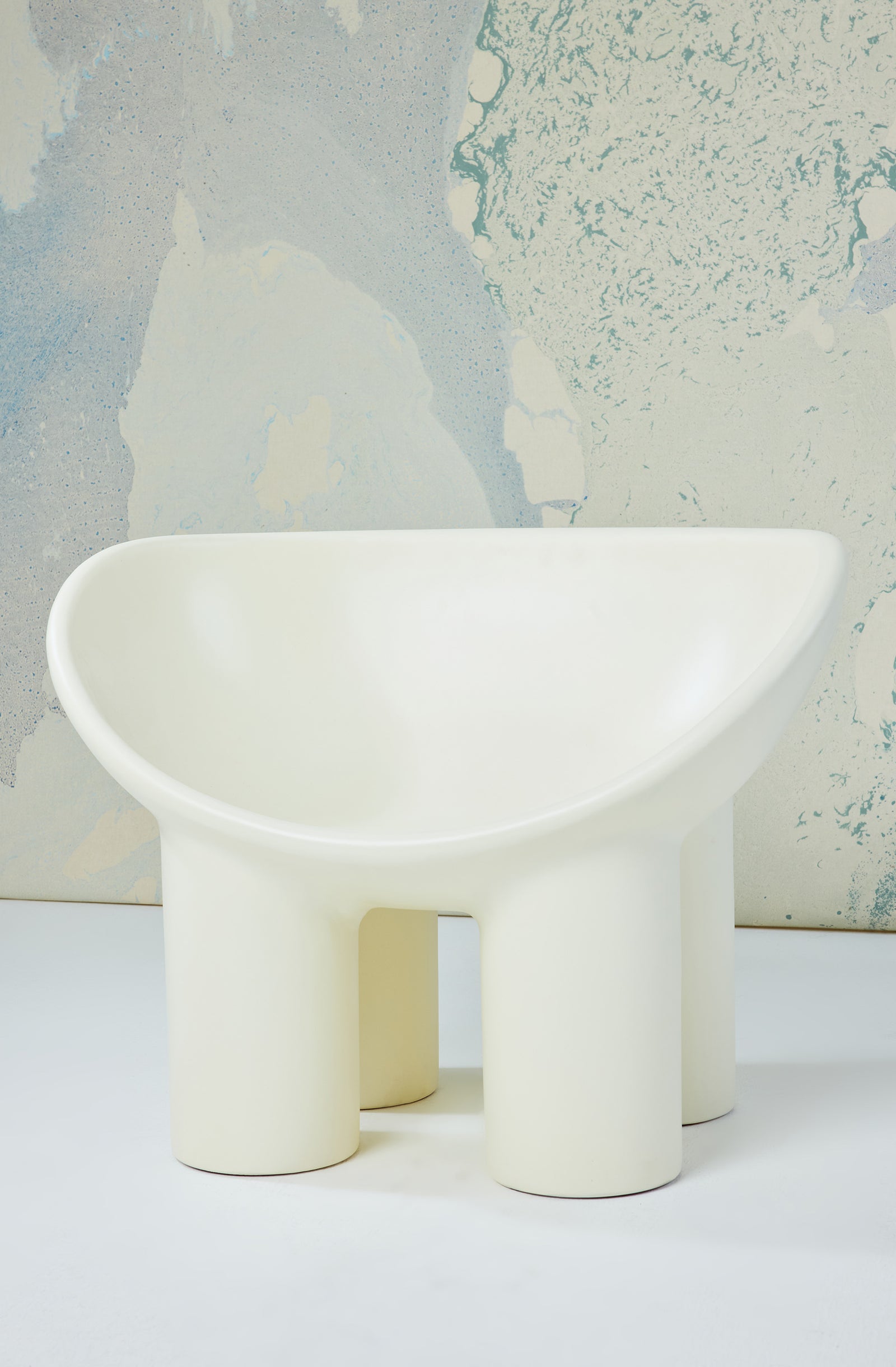 White piece of furniture with rounded edges and short cylindrical legs.